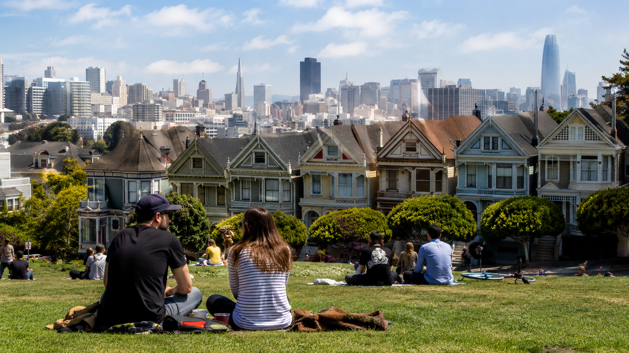 Why People Move to San Francisco People relaxing in a neighborhood park with Victorian homes and the downtown skyline in San Francisco, California.